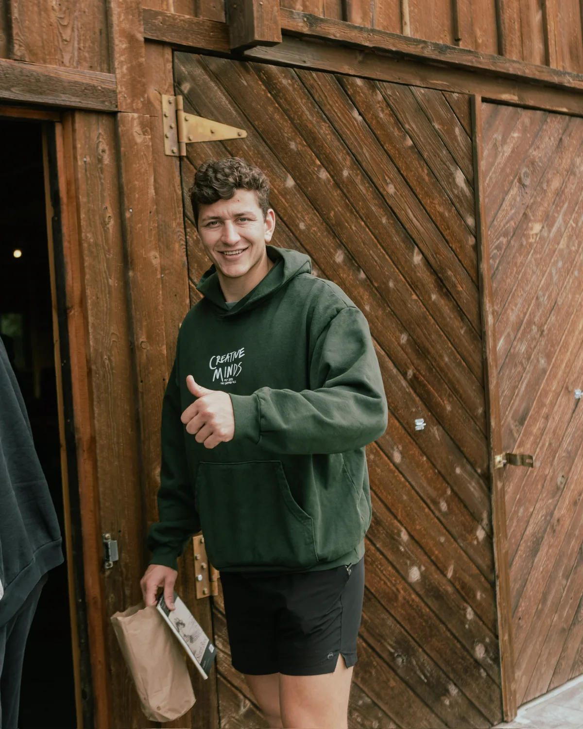Armin Jonker giving a thumbs up outside a barn at the Creative Minds retreat in Montana